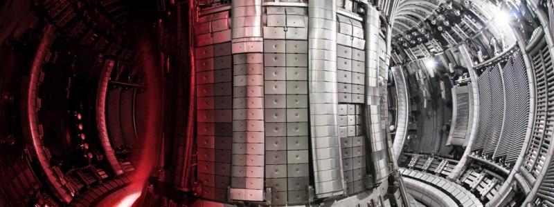 En tokamak, som på bilden, är en avancerad reaktortyp som används för att försöka producera energi genom kärnfusion – samma process som driver solen. I anläggningen ITER i södra Frankrike byggs världens största tokamak. Principen bygger på att väteisotoper hettas upp till extremt höga temperaturer så att de blir plasma. Detta plasma hålls svävande med hjälp av starka magnetfält i en ringformad kammare, så att det inte kommer i kontakt med väggarna. Målet är att få atomkärnor att slå samman och frigöra energi. Tokamaken i ITER ska visa att fusion kan ge mer energi än vad som krävs för att starta processen. Tekniken är dock mycket komplex. Utmaningar handlar om stabilitet i plasmat, material som tål värmen och enorma kostnader. ITER är ett forskningsprojekt – inte ett kommersiellt kraftverk. Foto: ITER