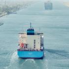 Ett stort containerfartyg med Maersks färger vid ingången till Suezkanalen, vars stränder omges här av grön vegetation. Foto: Maersk
