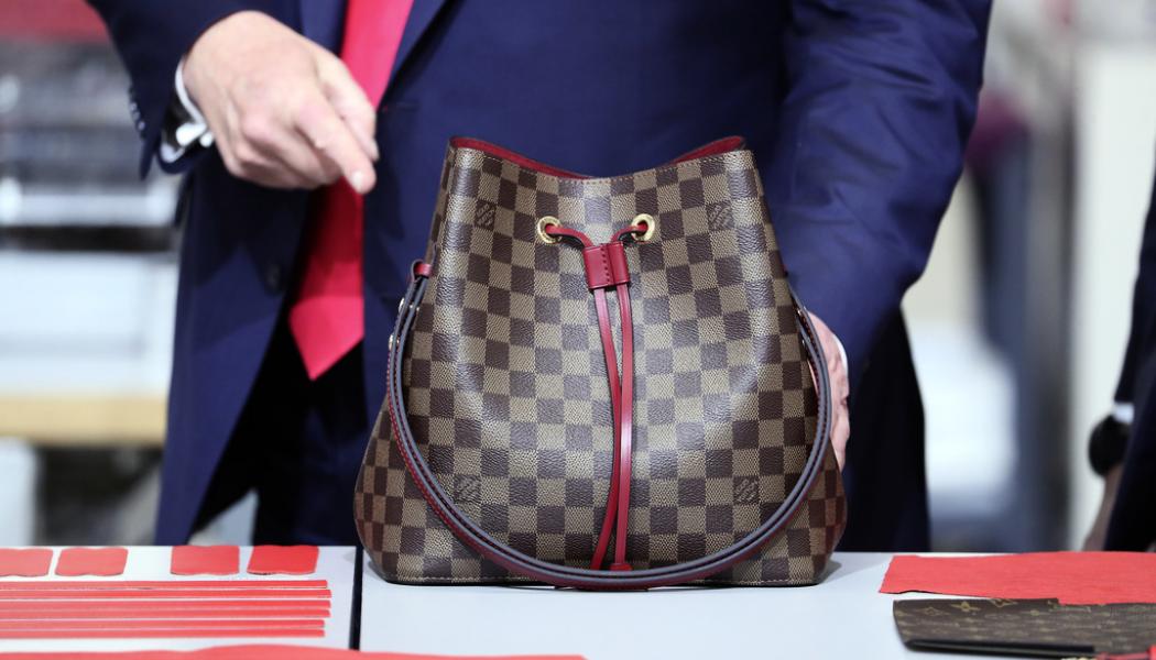 Andrew Harnik/AP/TT: Före detta president Donald Trump inspekterar en Louis Vuitton-väska. Arkivbild.