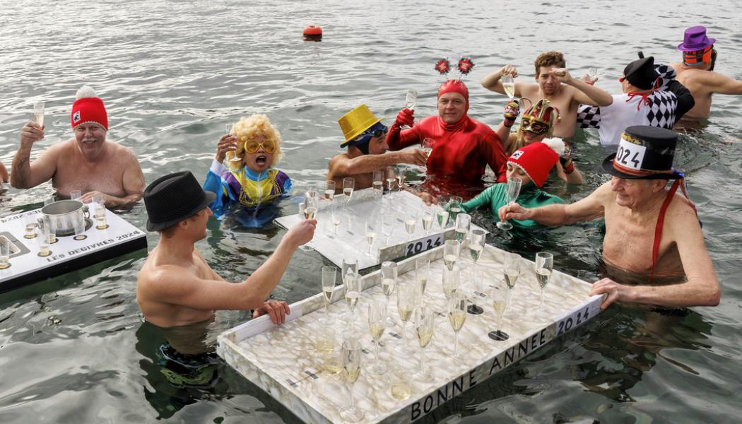 Salvatore Di Nolfi/AP/TT: Invånare i schweiziska Genève skålar i champagne vid det traditionella nyårsdoppet i Genèvesjön. Arkivbild.