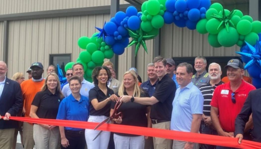 In the center of the photo, Vanécia Carr, EAM General Manager; Kim Sumner, EAM Director of Operations & Development; and Domtar Executive VP and Chief Operating Officer Steve Henry prepare to cut the ribbon on the EAM expansion. Photo: Domtar 