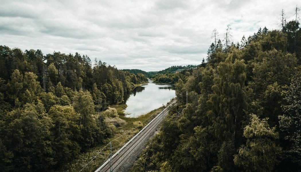Landskap med damm och järnvägsspår i Asker, Norge. Foto: Jeremi Joseph/Unsplash