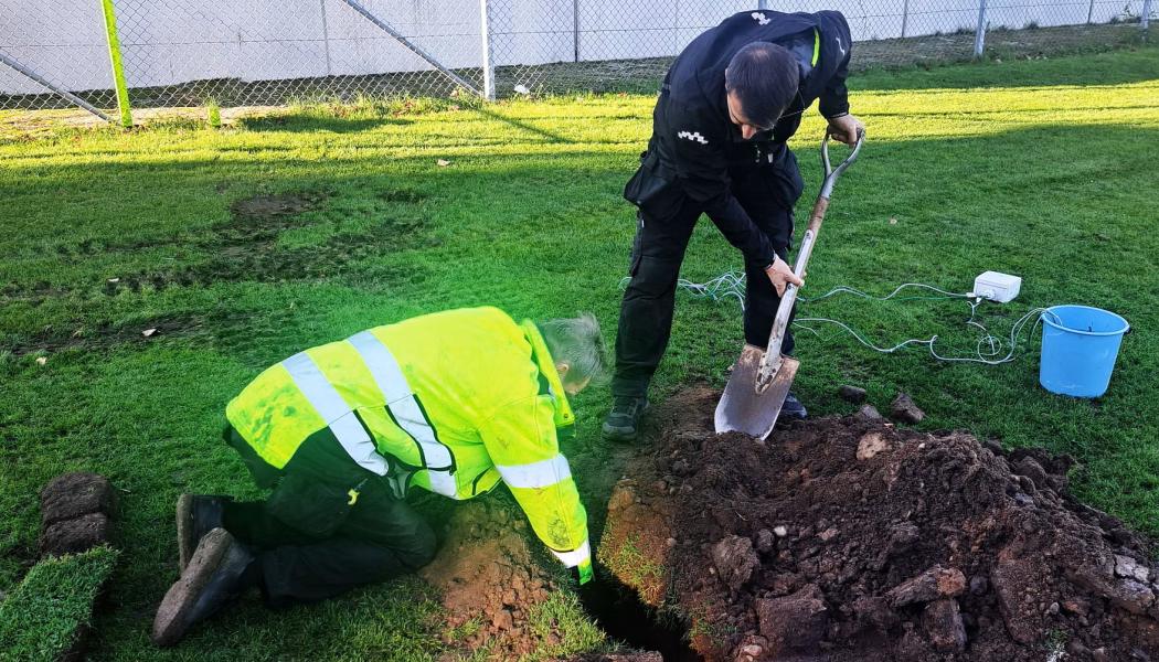 Personal från Idrottsservice gräver ner sensorer i en av kommunens gräsplaner. Foto: Andreas Narvå