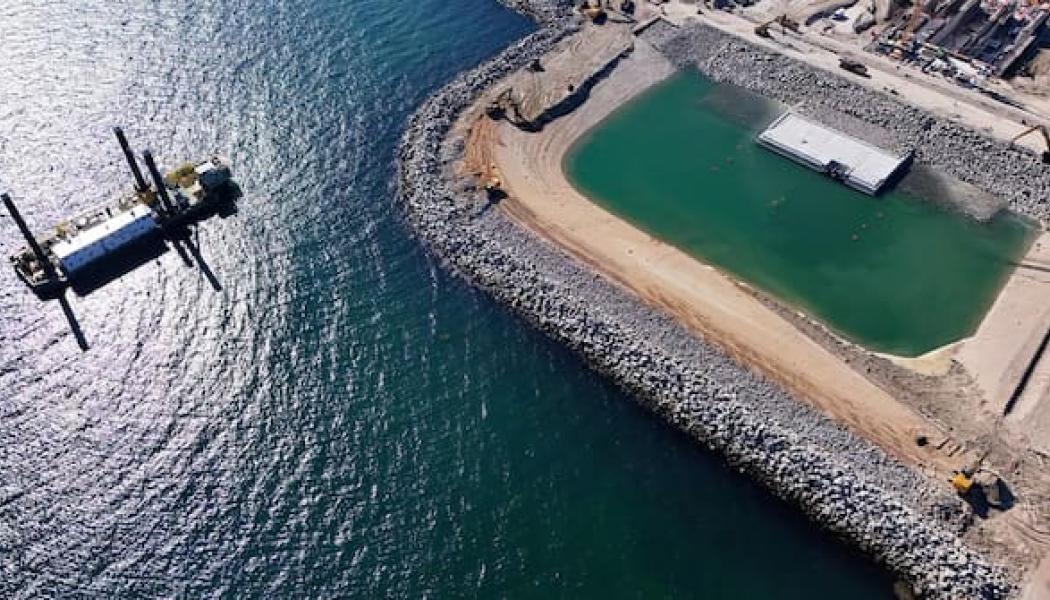 Den norra portalområdet har översvämmats så att den första tunneldelen nu ligger i vattnet. Den framförliggande vallen kommer härnäst att monteras ned. De övriga tunnelsektionerna kommer senare att anslutas till denna tunneldel. Foto: Femern A/S/Christian Huebner.