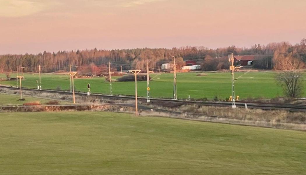 Järnvägsspår som löper genom ett öppet jordbrukslandskap Västra Götaland. Foto: Stina Wickenberg