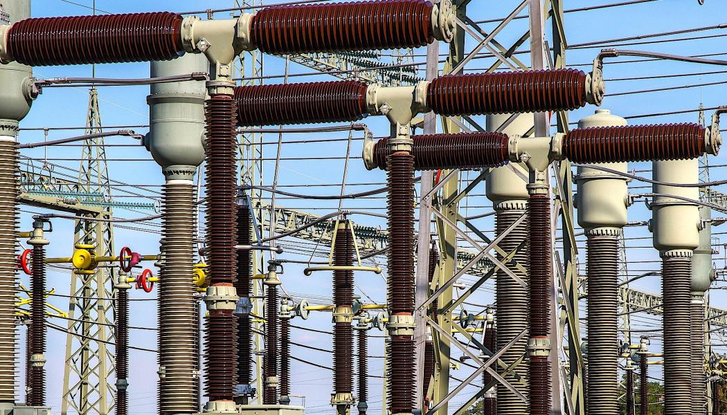 En transformatorstation (eller nätstation) i Tyskland. Dess primära funktion är att omvandla elektrisk spänning och distribuera elen säkert. Den fungerar som en knutpunkt i elnätet som tar emot högspänning och sänker den till en lägre, användbar spänning för hushåll och industrier. Foto: Creative Commons Lic. Kredit: Pixabay
