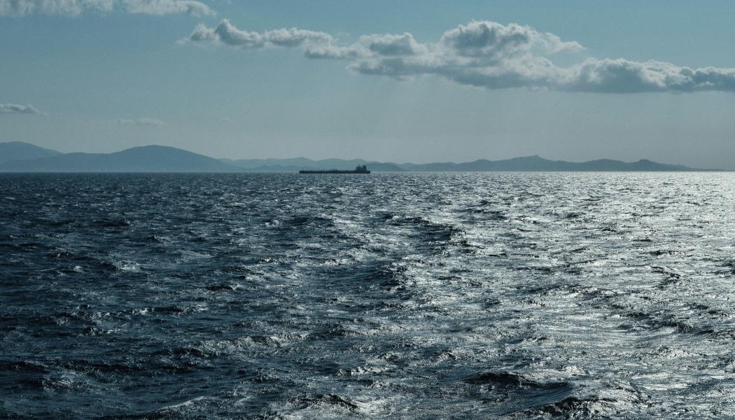 Genrebild på öppet hav med fartyg i fjärran. Foto: Giandomenico Pozzi/Unsplash