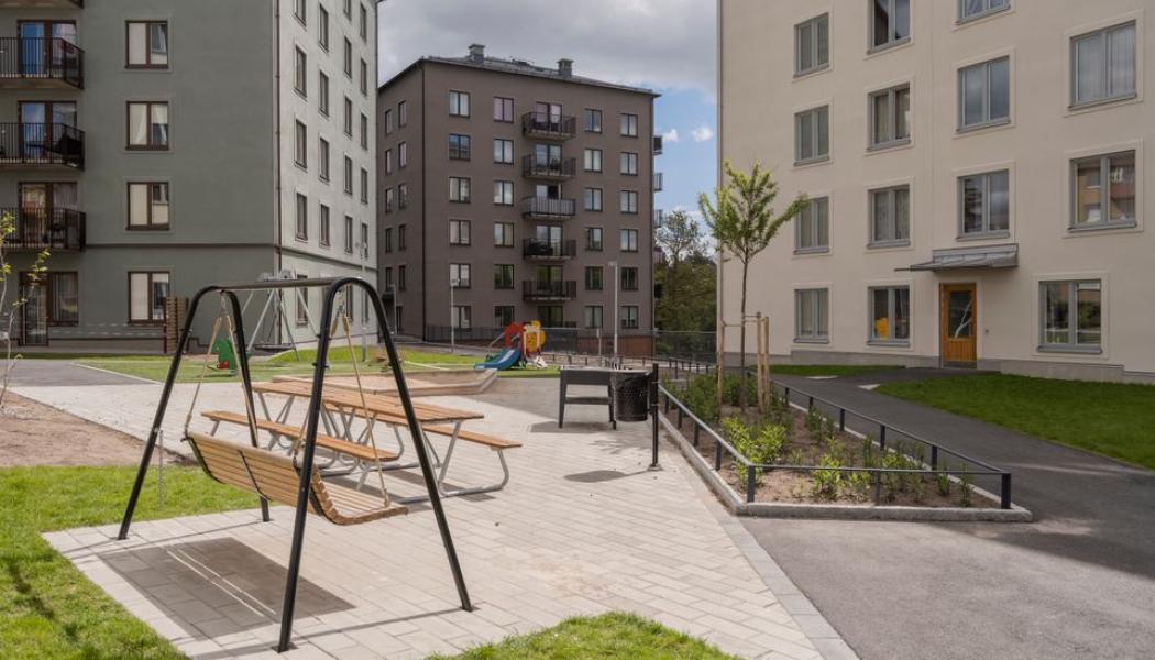 Bildtext: Lägenhetshus med en innergård framför. På gården står en hänggunga.
Svenska Bostäders Stockholmshus i Ledinge, Tensta. Foto: Svenska Bostäder/Peter Lydén