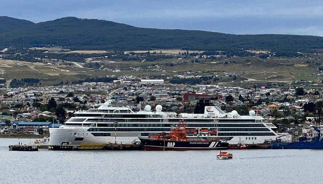 Viking Polaris ligger i hamnen i Chile för reparation efter att ha drabbats av en jättevåg ungefär tio dagar tidigare. Bilden togs den 12 december 2022 i Punta Arenas, som ligger i bakgrunden. Ett DAP-fartyg, liksom en tenderbåt från kryssningsfartyget Viking Jupiter, är i förgrunden. Foto: Wikipedia Common, Kredit: Nolabob