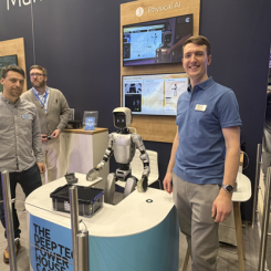 Dom Rugg-Gunn (till höger), robotikingenjör på Cambridge Consultants, vid bolagets monter på MWC 2026. Den humanoida roboten mellan teammedlemmarna är den som under mässan demonstrerade hur AI kan tolka mänskliga gester och plocka upp objekt. Foto: Nicholas Christiansen.