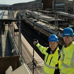 Infrastrukturarbeten vid Drammens station i Norge. Geir Boman Rinde (till vänster) och Morten E. Paulsen är båda byggledare för el på stationen. De visar glatt upp de första solpanelerna som installerades på plattformstaket vid floden.
Foto: Anne Mette Storvik, Bane NOR